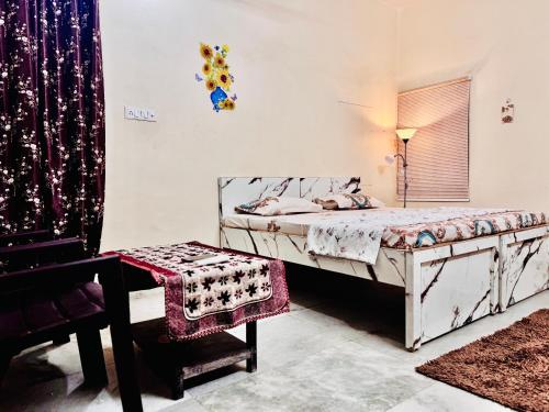 a bedroom with a bed and a chair and a window at SR Residence in Kaliānpur