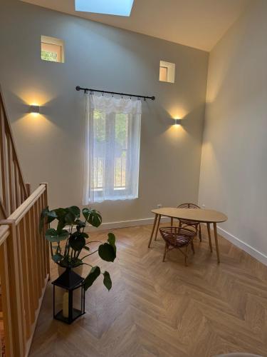a living room with a table and a potted plant at La Parenthèse Naillousaine in Nailloux
