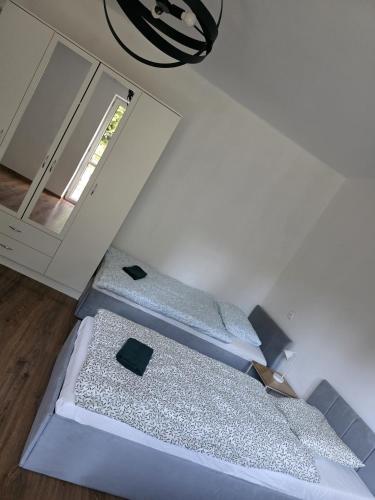 two beds in a room with a mirror at Pokoje gościnne u Wiktorii in Sąspów
