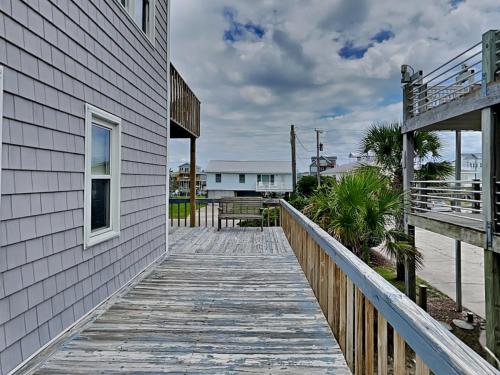 a wooden walkway next to a building with a balcony at Hoff 1 in Topsail Beach