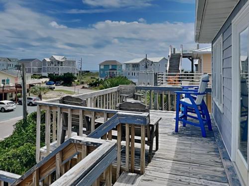 a deck with a blue table and chairs on a house at Hoff 1 in Topsail Beach