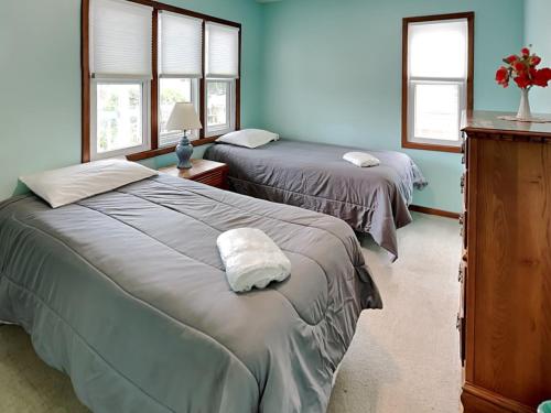 two beds in a room with blue walls and windows at Hoff 1 in Topsail Beach
