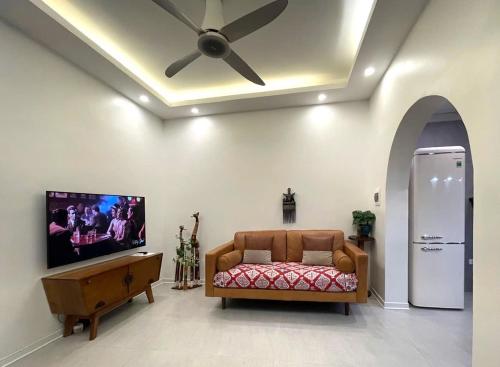 a living room with a couch and a ceiling fan at Peaceful house in Hanoi