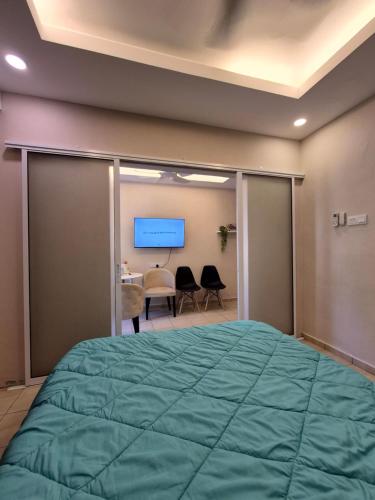 a bedroom with a large green bed and a desk at Clover Studiostay in Labuan