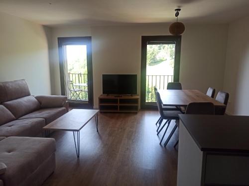 a living room with a couch and a table at Apartament FREIXE de Molló Parc in Molló