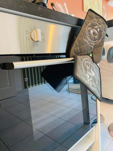 a oven with its door open in a kitchen at La Perle - Jacuzzi - Wifi - Parking PV in Lunel