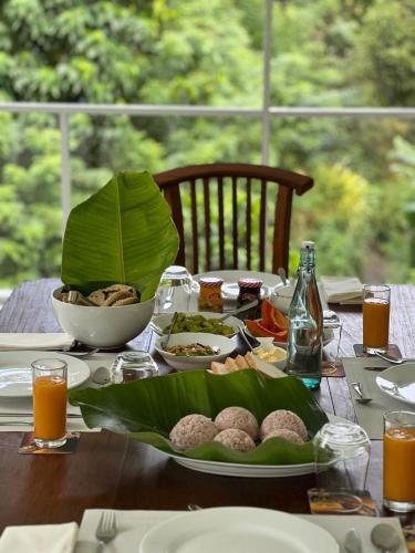 a wooden table with a plate of food on it at Tea Heritage in Urulewatta