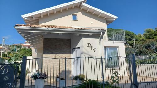 a white house with a fence in front of it at La Perla DP in Ricadi