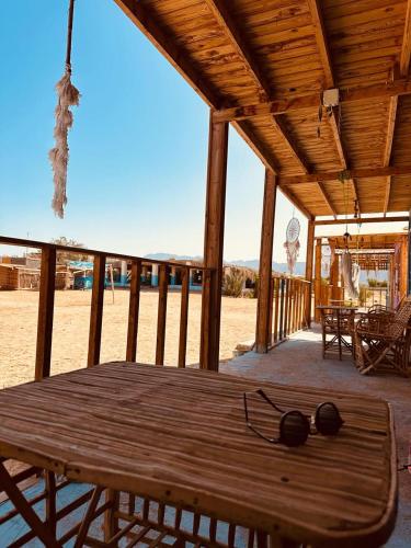 a wooden deck with a table and glasses on it at Dream Beach camp in Wāsiţ