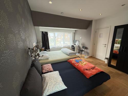 a bedroom with a bed with pillows on it at The Beautiful White House in Kortenberg