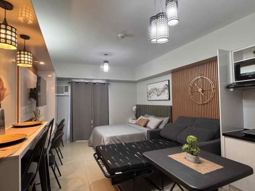 a room with a bed and a kitchen with a table at Louritto Studio Type Condo at Avida Towers Riala Tower 3 in Cebu City