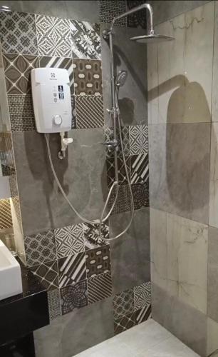 a shower in a bathroom with a sink at Comfort Suite in Miri in Miri