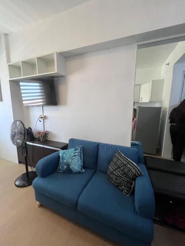 a blue couch with pillows in a living room at Avida tower 2 in Davao City