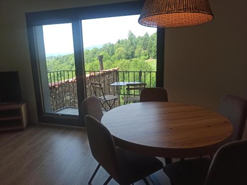 a dining room with a table and chairs and a large window at Apartament ROURE de Molló Parc in Molló