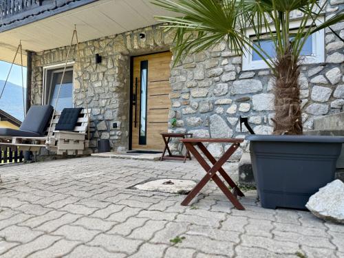 a patio with a table and chairs and a stone wall at Haus am Berch in Weissenstein