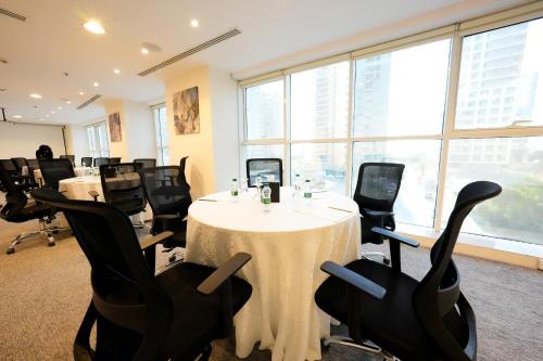 a conference room with a white table and black chairs at Myrtle AlSahafa Hotel فندق ميرتل الصحافه in Riyadh