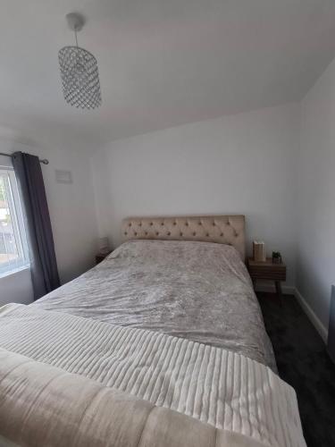 a bed in a white bedroom with a large mattress at Florence House in Bradford
