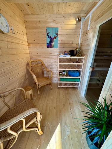 a room with two chairs and a clock on a wall at Schwarzwaldliebe Ferienwohnung mit eigenem Garten in Gaggenau