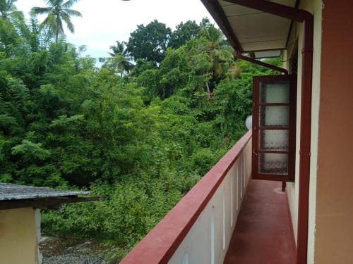 a balcony of a house with a view of trees at Priyantha's Place in Kahawa