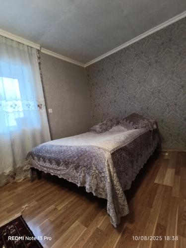 a bedroom with a bed in a room with a window at Riverside in Xınalıq