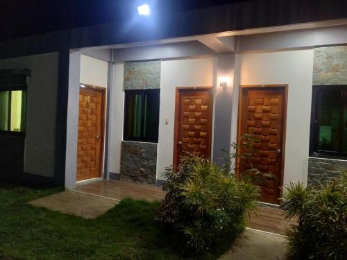 a house with two wooden doors at night at Lalies Inn in Batuan