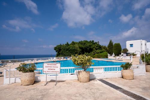 a swimming pool with a sign in front of it at Aetheria 3BR in Khlorakas