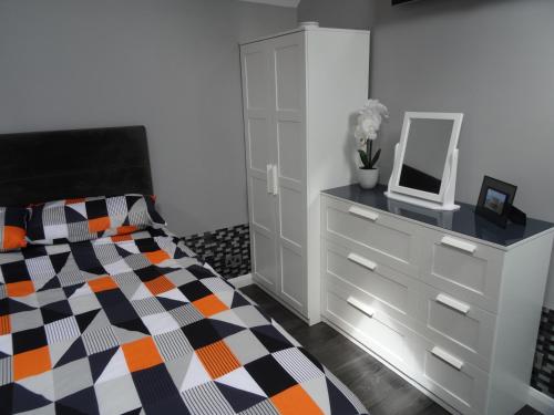 a bedroom with a bed and a dresser with a mirror at Lazy Lodge in Foxdale