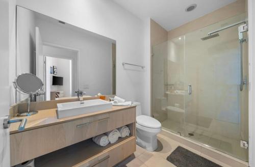 a bathroom with a sink and a toilet and a shower at Stunning Beach Front Condo Ocean View Pool Spa in Hollywood
