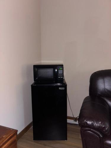 a microwave sitting on top of a black refrigerator at Carepoint Residence in Lawnside