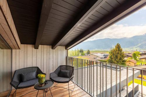 a balcony with two chairs and a table at Emma Deluxe Aparthotel ganzjährig beheizter Außenpool in Piesendorf