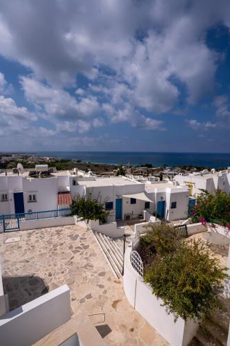 a view of a town with white buildings and the ocean at Aetheria 3BR in Khlorakas