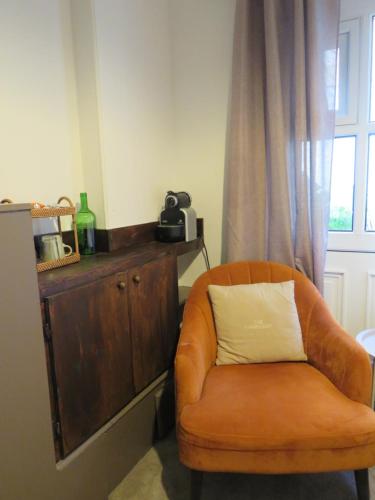 an orange chair with a white pillow in a room at Arch Guesthouse in Clifden