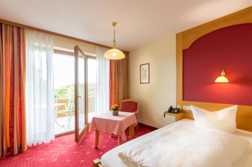 a hotel room with a large bed and a table at Hotel Astoria - Alexandra Krämer eK in Bad Füssing