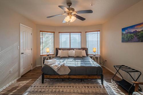 a bedroom with a bed and a ceiling fan at NEW Desert Daze, near Golf, Heated Pool+Spa, 12ppl in Scottsdale