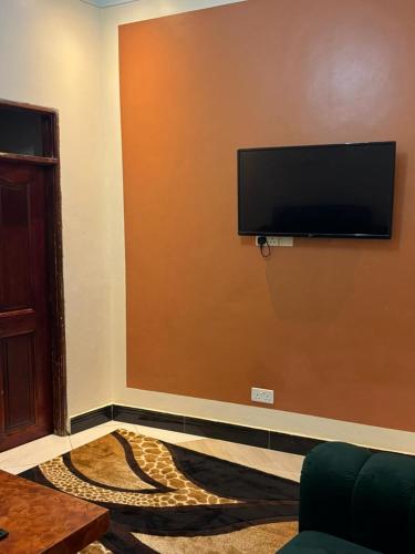 a living room with a flat screen tv on a wall at Moods Holiday homes in Kampala