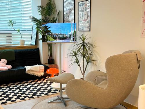 a living room with a chair and a couch at Hongdae Station Link House with Massage Chair in Seoul