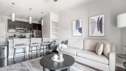 a living room with a couch and a kitchen at Landing Stunning 1BD Clubhouse Gym in Katy
