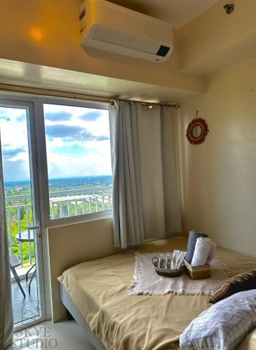 a bedroom with a bed and a balcony at Tagaytay Condo - Skye Studio in Kaybagal