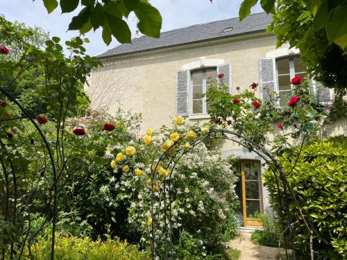 an archway in front of a house with flowers at Il était une fois un jardin in Saint-Fargeau