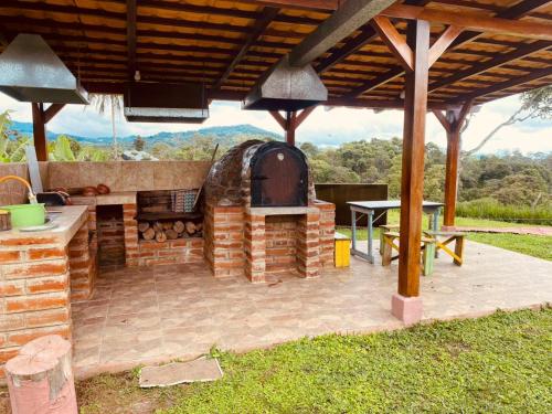 a patio with an outdoor grill and a table at CAMVUL Farm Lodge - Finca Hotel in Palmito Palma