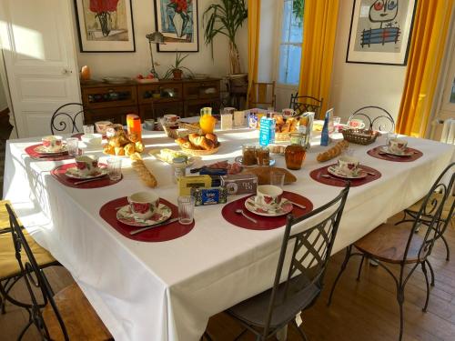 a white table with food and drinks on it at Il était une fois un jardin in Saint-Fargeau