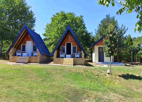 a small house with a blue roof on a field at Dunavska Priča in Negotin