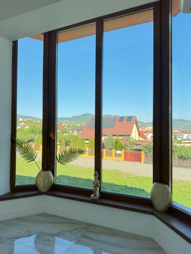 a room with three windows with a view of a yard at Pensiune Simona in Deva