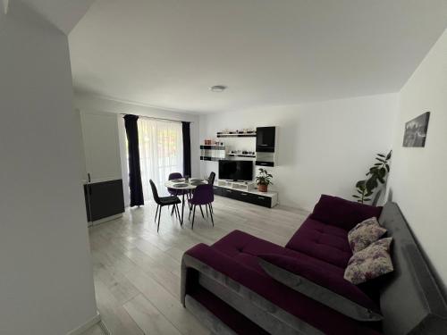 a living room with a purple couch and a table at Forest View in Câmpulung Moldovenesc