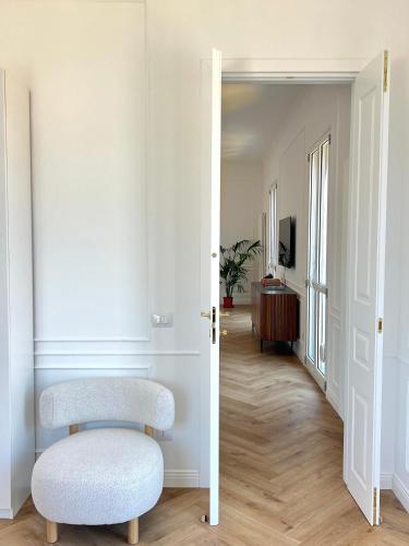 a white hallway with a chair and a mirror at LEtoile du Lac in Blevio