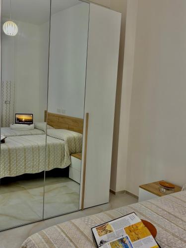a bedroom with two beds and a glass closet at La Casa di Anna, a un passo dal mare in Rapallo