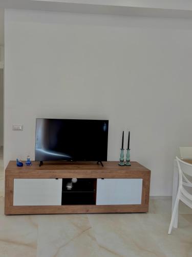 a living room with a tv on a wooden table at La Casa di Anna, a un passo dal mare in Rapallo