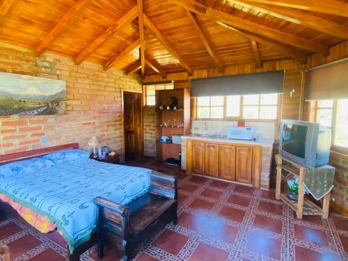 a bedroom with a bed and a tv in a room at CAMVUL Farm Lodge - Finca Hotel in Palmito Palma