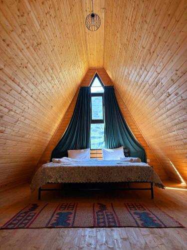 una cama en una habitación con ventana en Memoria Kazbegi, en Arsha