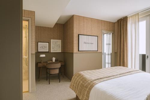 a bedroom with a bed and a desk and a window at Le Goyen in Audierne